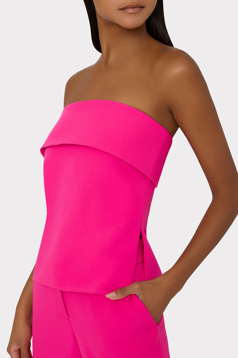 Pink strapless top worn by a model on a white background