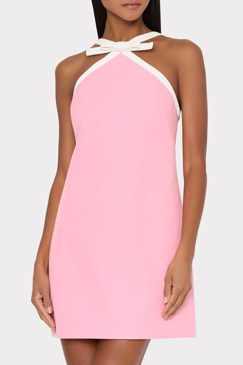 Pink dress with white halter neckline on a plain background
