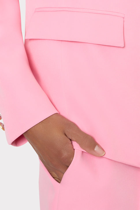 Close-up of a pink suit with a hand touching the fabric