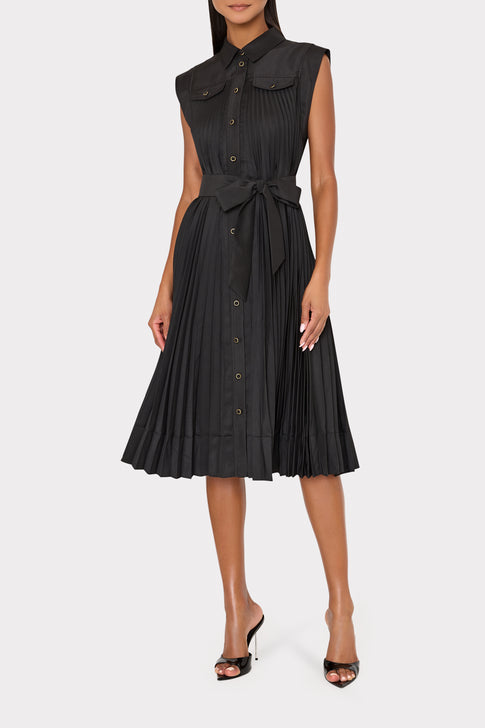 Black pleated dress worn by a model on a white background