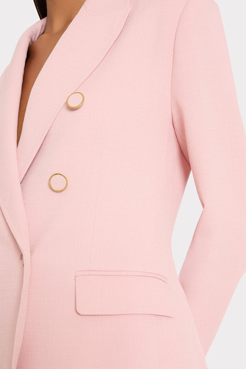 Close-up of a pink blazer with gold buttons on a light background