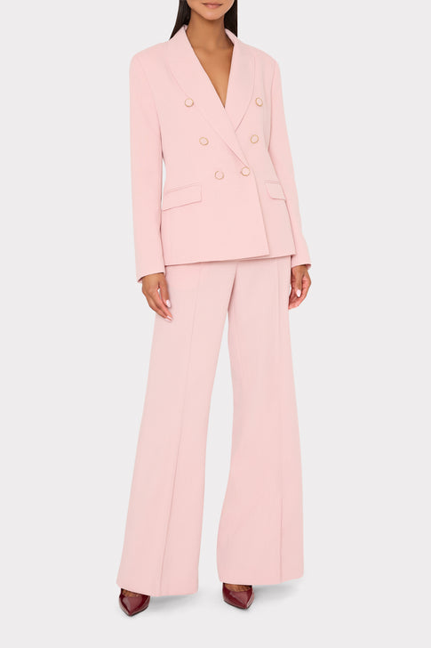 Person wearing a light pink suit on a white background