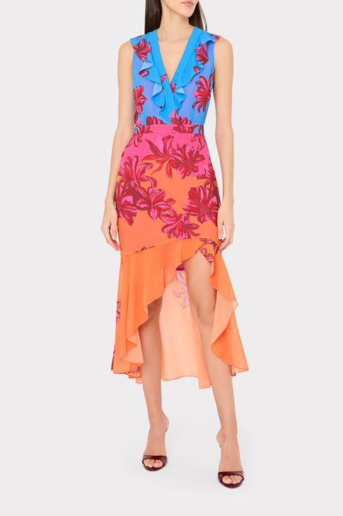 Woman wearing a colorful floral dress with a blue top and orange skirt on a white background
