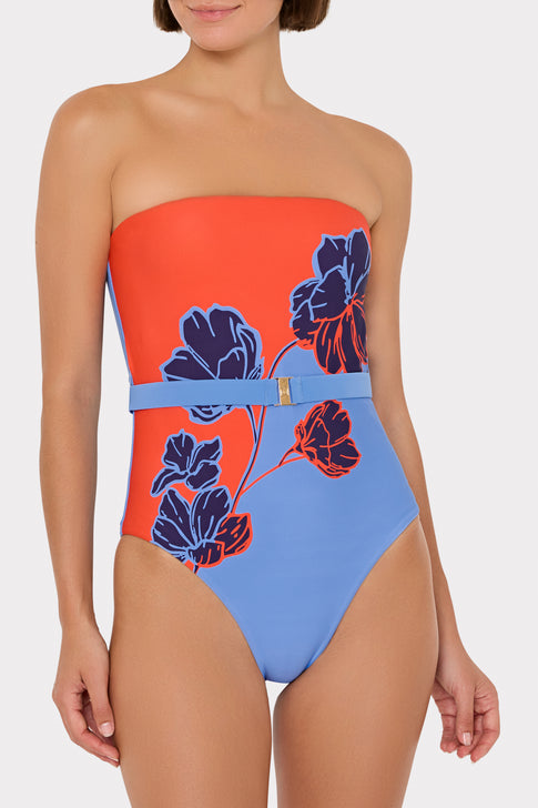 Model wearing orange & blue strapless floral swimsuit with belt detail | MILLY