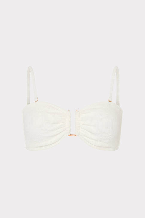 White bikini top with thin straps on a light beige background