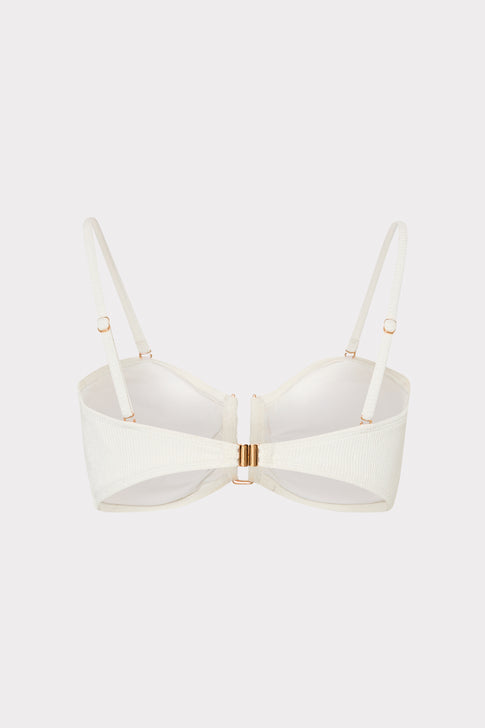 White bikini top with thin straps on a light beige background