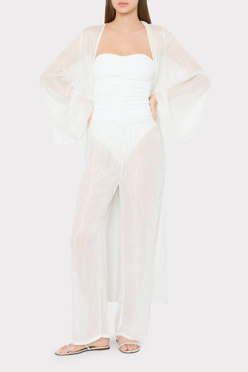 Model wearing white swimsuit with sheer pinstripe cover-up pants and cardigan - Complete Look | MILLY