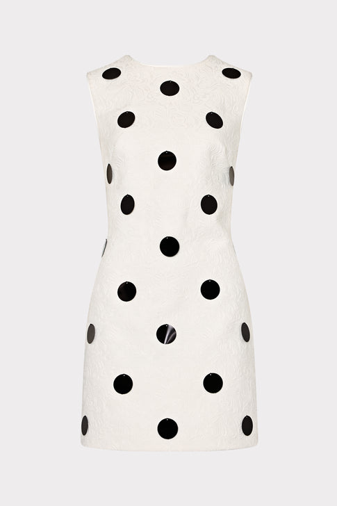 White sleeveless dress with black polka dots on a white background