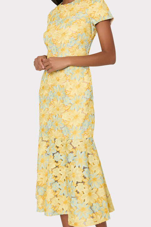 Yellow floral dress worn by a person on a light gray background