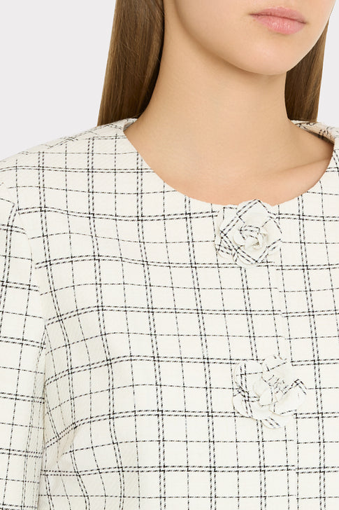 Close-up of black and white checkered jacket with floral button detail | MILLY