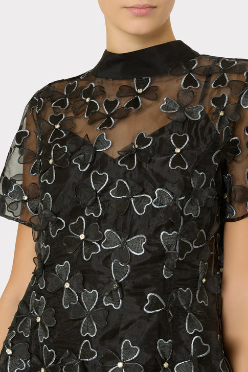 Black dress with floral embroidery on a plain background