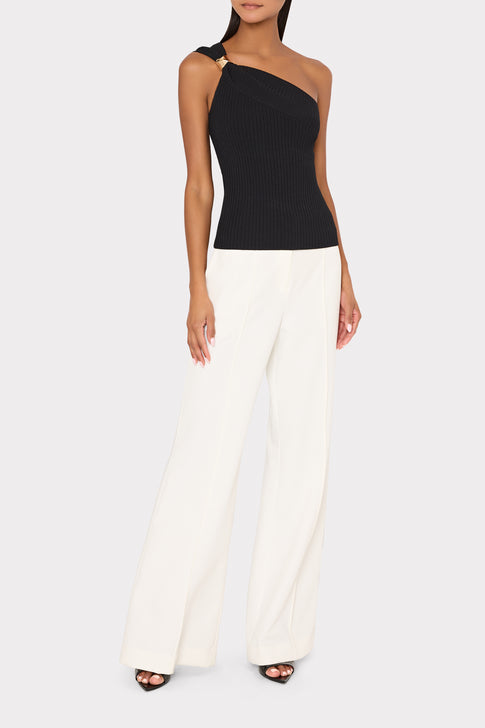 Woman wearing black one-shoulder Sivan top and white pants styled for designer look | MILLY