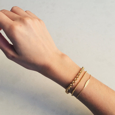 Gold Rolo Bracelet Styled with Delicate Chain Bracelets - On Wrist | MILLY